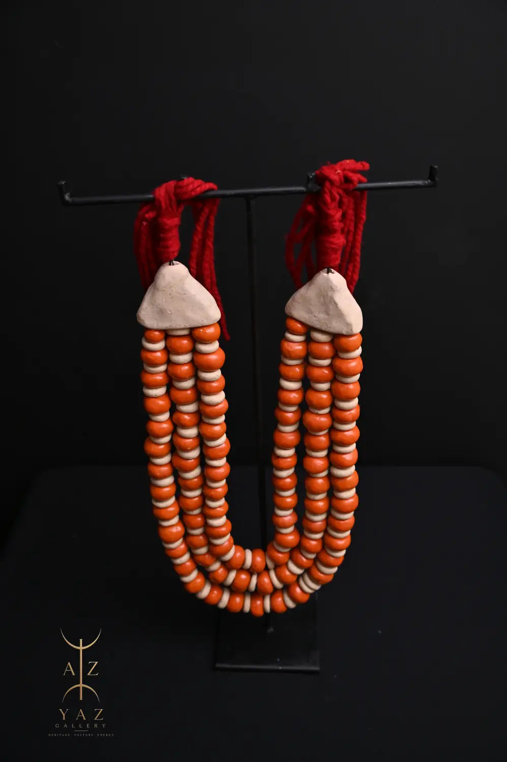Sunset Ember Pendant Sculpture – Ivory & Orange Beads with Red Rope on Black Stand (62 x 34 cm)