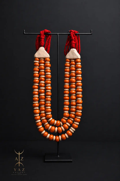 Sunset Ember Pendant Sculpture – Ivory & Orange Beads with Red Rope on Black Stand (62 x 34 cm)