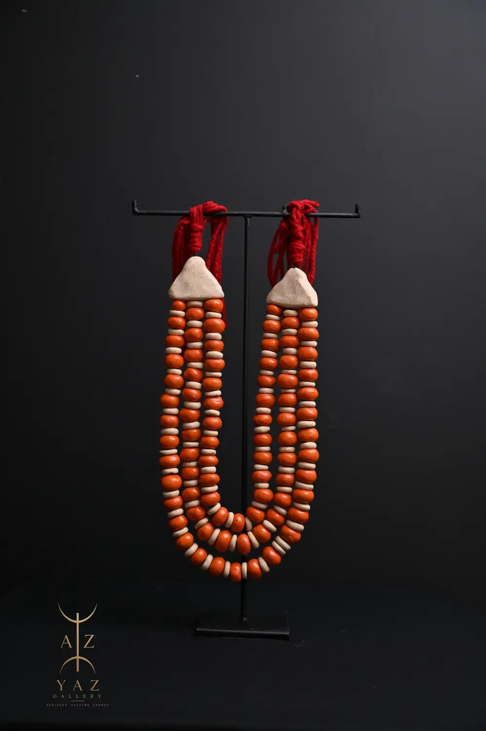 Sunset Ember Pendant Sculpture – Ivory & Orange Beads with Red Rope on Black Stand (62 x 34 cm)