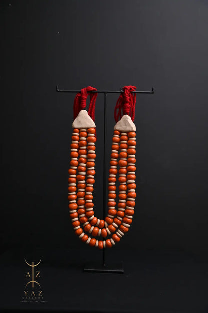 Sunset Ember Pendant Sculpture – Ivory & Orange Beads with Red Rope on Black Stand (62 x 34 cm)