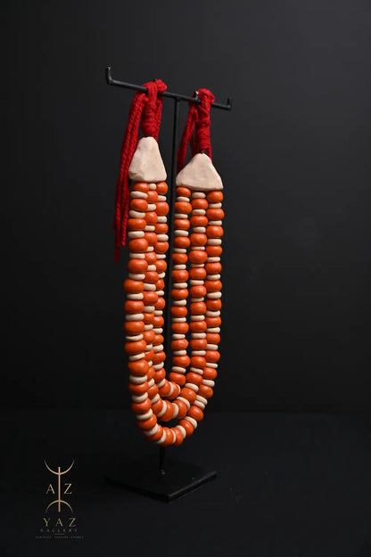 Sunset Ember Pendant Sculpture – Ivory & Orange Beads with Red Rope on Black Stand (62 x 34 cm)