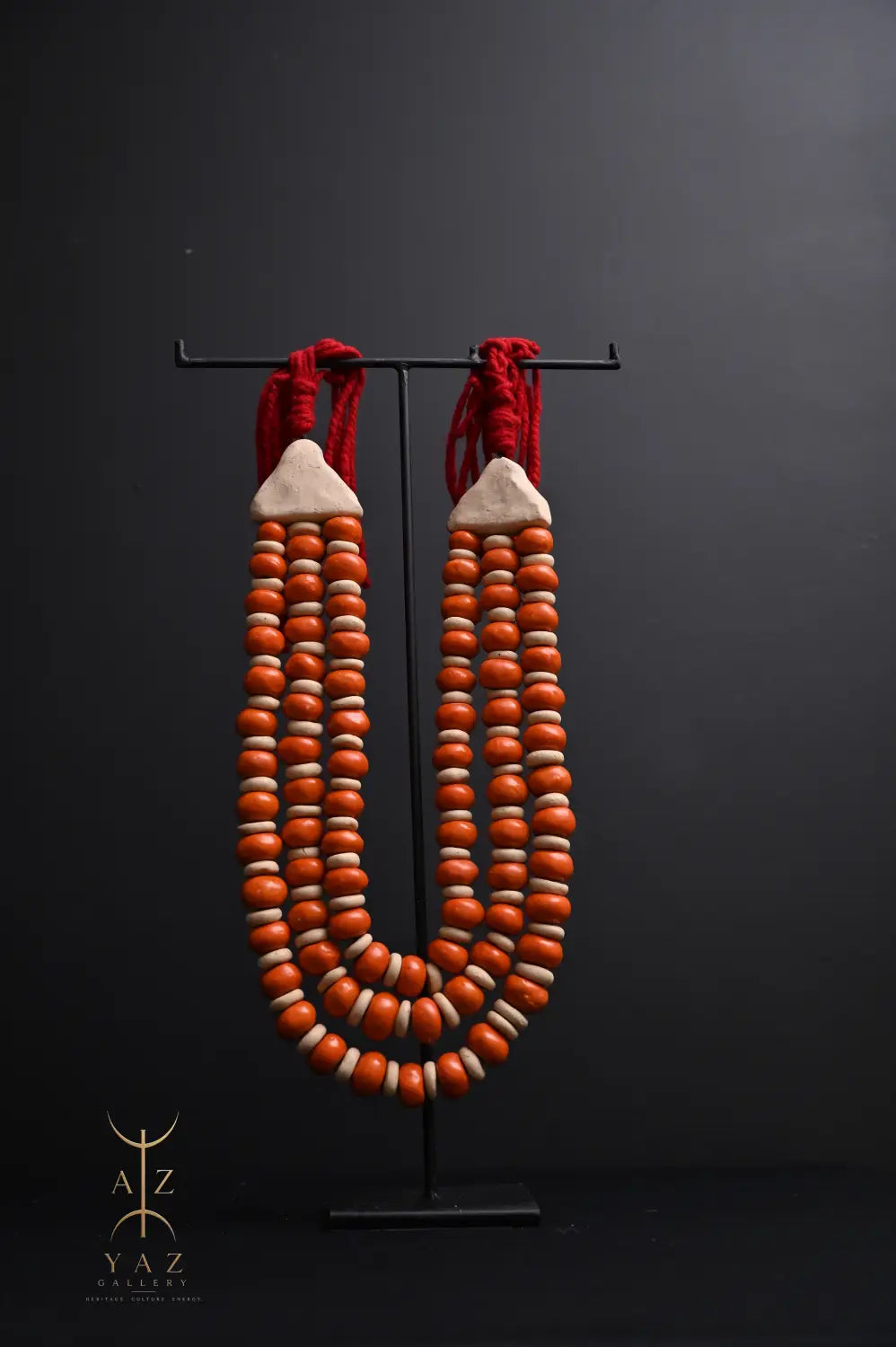 Sunset Ember Pendant Sculpture – Ivory & Orange Beads with Red Rope on Black Stand (62 x 34 cm)
