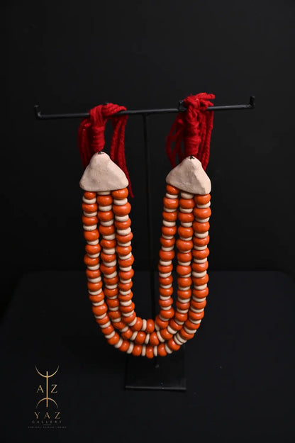 Sunset Ember Pendant Sculpture – Ivory & Orange Beads with Red Rope on Black Stand (62 x 34 cm)